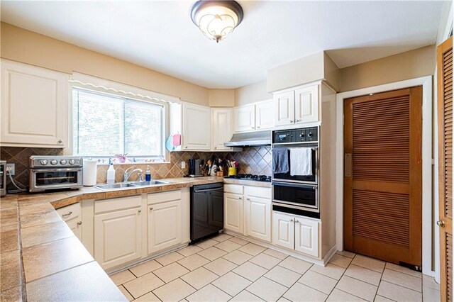 966-968 Allen Toussaint Blvd, New Orleans, LA 70124 - kitchen featuring black dishwasher, a sink, under cabinet range hood, and backsplash