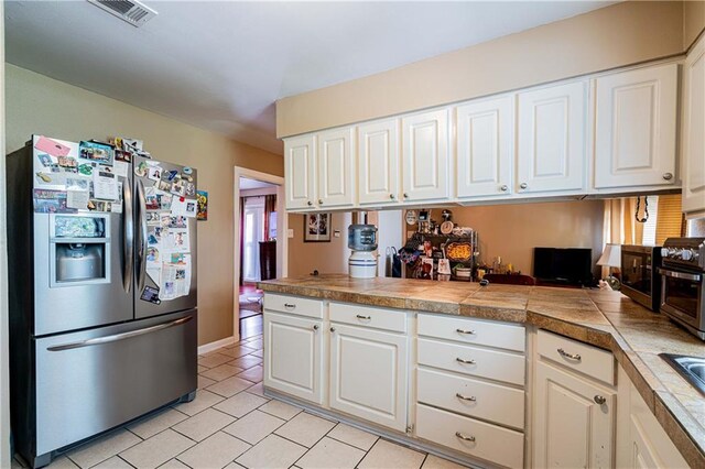 966-968 Allen Toussaint Blvd, New Orleans, LA 70124 - kitchen featuring stainless steel fridge, light tile patterned floors, and white cabinets