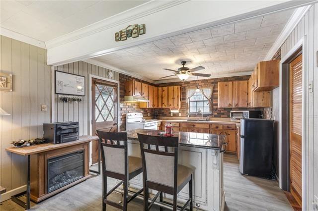 5679 Jean Lafitte Blvd, Jean Lafitte, LA 70067 - kitchen with ornamental molding, white range with electric stovetop, brown cabinets, freestanding refrigerator, and under cabinet range hood