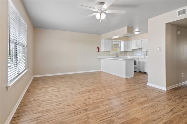 2713 Independence St, Metairie, LA 70006 - unfurnished living room featuring light wood-style flooring, baseboards, ceiling fan, and a sink