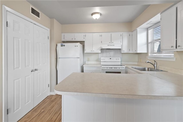 2713 Independence St, Metairie, LA 70006 - kitchen featuring white appliances, a sink, under cabinet range hood, light countertops, and a peninsula