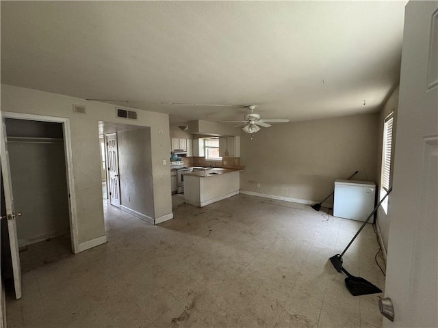 2713 Independence St, Metairie, LA 70006 - unfurnished living room with a ceiling fan, light floors, and baseboards
