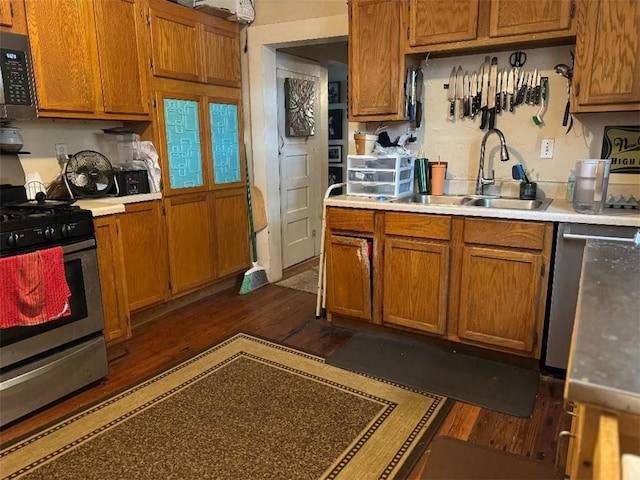 5621 Tchoupitoulas St, New Orleans, LA 70115 - kitchen featuring stainless steel range with gas stovetop, dark wood finished floors, brown cabinets, and light countertops