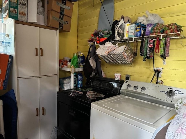 5621 Tchoupitoulas St, New Orleans, LA 70115 - washroom featuring wood walls, washing machine and dryer, and cabinet space