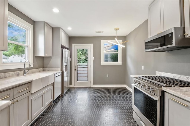 226 Lions St, Jefferson, LA 70121 - kitchen with appliances with stainless steel finishes, pendant lighting, recessed lighting, light stone counters, and gray cabinets