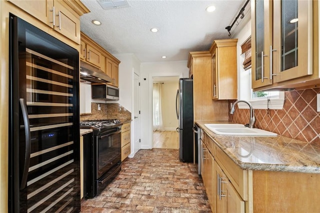 4517 Bissonet Dr, Metairie, LA 70003 - kitchen with a sink, appliances with stainless steel finishes, brick floors, under cabinet range hood, and light stone counters