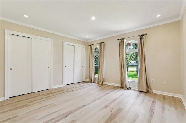 4517 Bissonet Dr, Metairie, LA 70003 - unfurnished bedroom featuring multiple closets, light wood finished floors, ornamental molding, baseboards, and recessed lighting