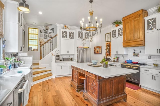 205 S Norman C Francis Pkwy, New Orleans, LA 70119 - kitchen with stainless steel appliances, crown molding, backsplash, light countertops, and a chandelier