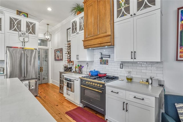 205 S Norman C Francis Pkwy, New Orleans, LA 70119 - kitchen featuring gas stove, freestanding refrigerator, light countertops, white cabinetry, and tasteful backsplash