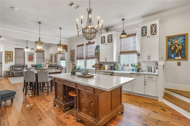 205 S Norman C Francis Pkwy, New Orleans, LA 70119 - kitchen featuring a chandelier, a center island, light countertops, light wood-type flooring, and white cabinetry