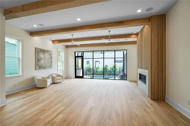 7104 Coliseum St, New Orleans, LA 70118 - unfurnished living room with baseboards, light wood finished floors, a glass covered fireplace, ceiling fan, and beam ceiling