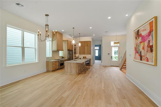 7104 Coliseum St, New Orleans, LA 70118 - kitchen with premium appliances, a chandelier, light countertops, a sink, and recessed lighting