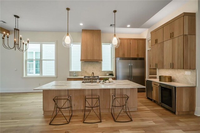7104 Coliseum St, New Orleans, LA 70118 - kitchen with built in fridge, wine cooler, backsplash, light wood-style floors, and recessed lighting