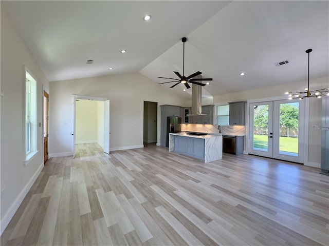 1421 David Dr, Metairie, LA 70003 - unfurnished living room featuring french doors, lofted ceiling, baseboards, light wood-style flooring, and recessed lighting