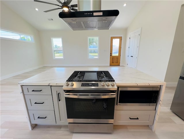 1421 David Dr, Metairie, LA 70003 - kitchen with stainless steel appliances, wall chimney exhaust hood, light stone counters, vaulted ceiling, and a ceiling fan