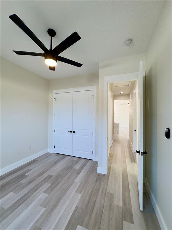 1421 David Dr, Metairie, LA 70003 - unfurnished bedroom with light wood finished floors, baseboards, a closet, and ceiling fan