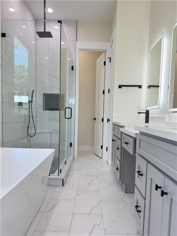 1421 David Dr, Metairie, LA 70003 - bathroom with a shower stall, a freestanding tub, vanity, recessed lighting, and marble look tiles