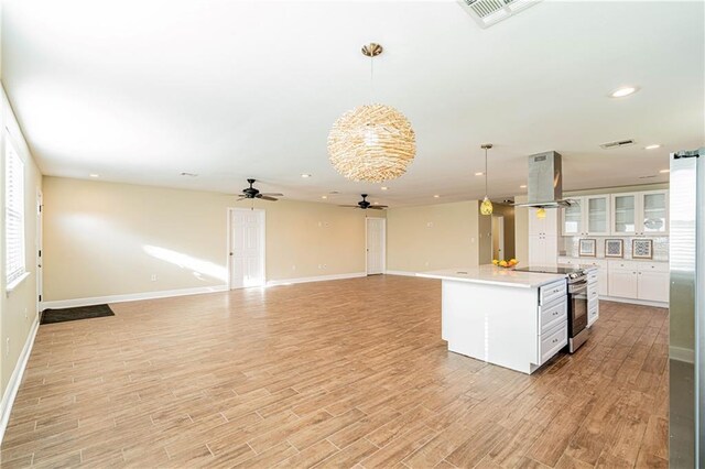 234 Murray Hill Dr, Destrehan, LA 70047 - kitchen featuring island range hood, electric stove, ceiling fan, white cabinetry, and light countertops