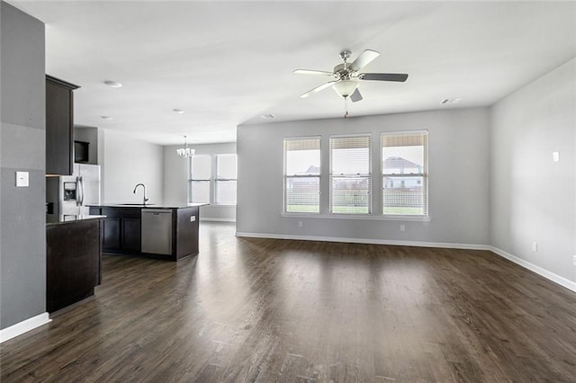 728 Lakeshore Village Dr, Slidell, LA 70461 - unfurnished living room featuring dark wood-type flooring, baseboards, and plenty of natural light