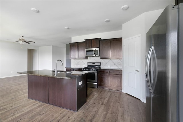 728 Lakeshore Village Dr, Slidell, LA 70461 - kitchen featuring stainless steel appliances, a sink, dark wood-style flooring, and decorative backsplash