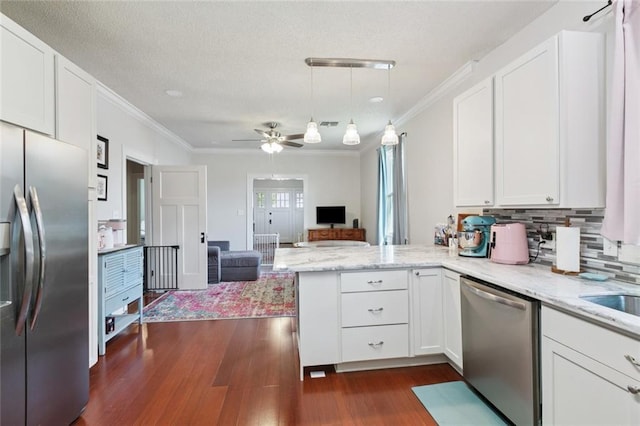 220 Moss Ln, River Ridge, LA 70123 - kitchen with stainless steel appliances, a peninsula, dark wood-type flooring, open floor plan, and white cabinetry