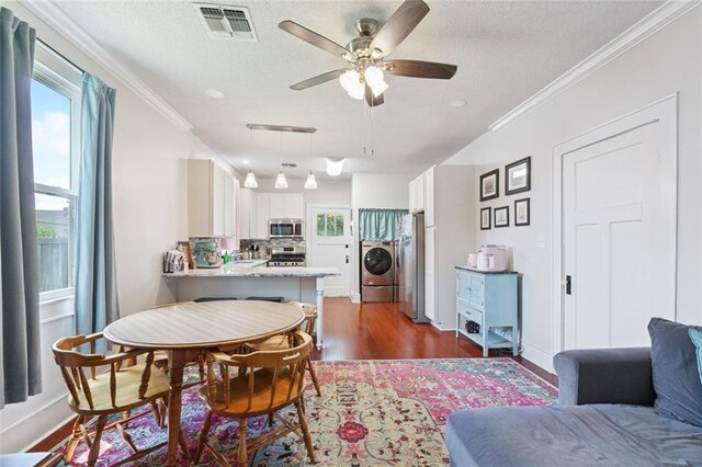 220 Moss Ln, River Ridge, LA 70123 - dining room featuring washer / dryer, a textured ceiling, ornamental molding, dark wood-style floors, and ceiling fan