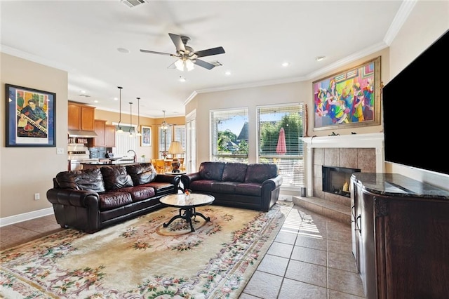 422 Kensington Blvd, Slidell, LA 70458 - tiled living room with healthy amount of natural light, a ceiling fan, crown molding, recessed lighting, and a fireplace with raised hearth