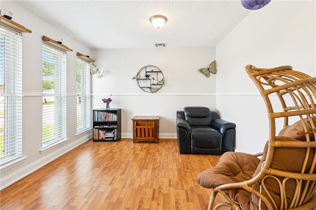 4060 S Windmere St, Harvey, LA 70058 - sitting room featuring light wood finished floors, baseboards, and a textured ceiling