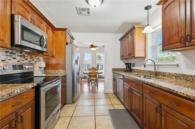 4060 S Windmere St, Harvey, LA 70058 - kitchen featuring appliances with stainless steel finishes, a sink, ceiling fan, backsplash, and stone countertops