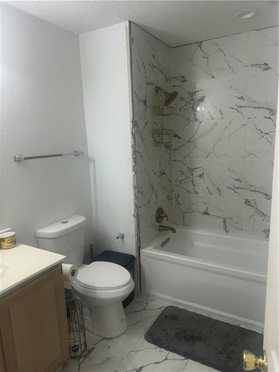 2227 Pine Valley Dr, La Place, LA 70068 - bathroom with vanity,  shower combination, toilet, marble finish flooring, and a textured ceiling