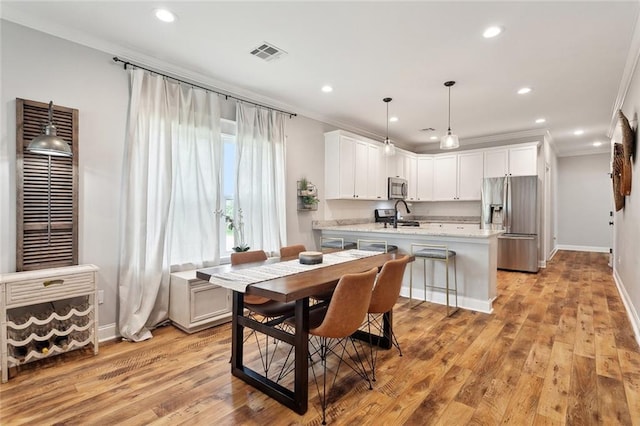 139 Abita Oaks Loop, Abita Springs, LA 70420 - dining area featuring crown molding, recessed lighting, light wood finished floors, and baseboards