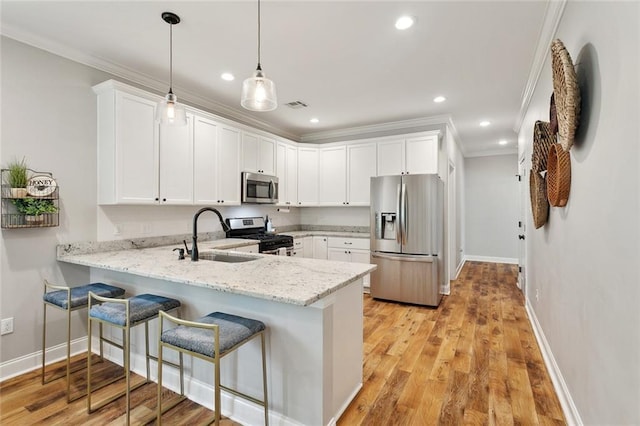 139 Abita Oaks Loop, Abita Springs, LA 70420 - kitchen with stainless steel appliances, a sink, ornamental molding, a peninsula, and white cabinets