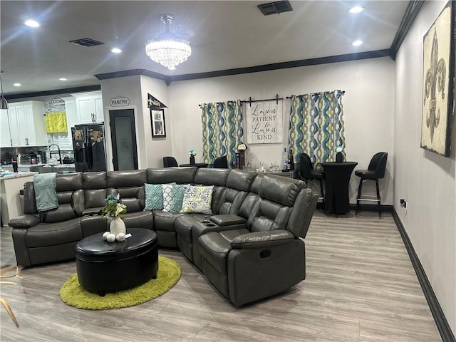 131 Belle Grove Dr, La Place, LA 70068 - living area with crown molding, light wood-type flooring, a chandelier, and recessed lighting
