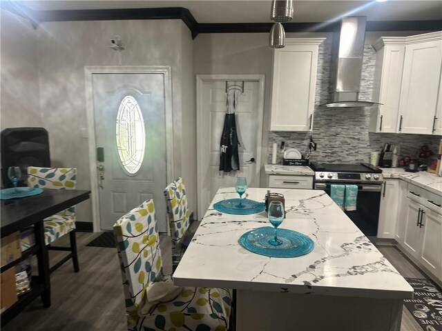 131 Belle Grove Dr, La Place, LA 70068 - kitchen featuring wall chimney range hood, stainless steel range with electric cooktop, dark wood-style floors, a kitchen island, and white cabinets