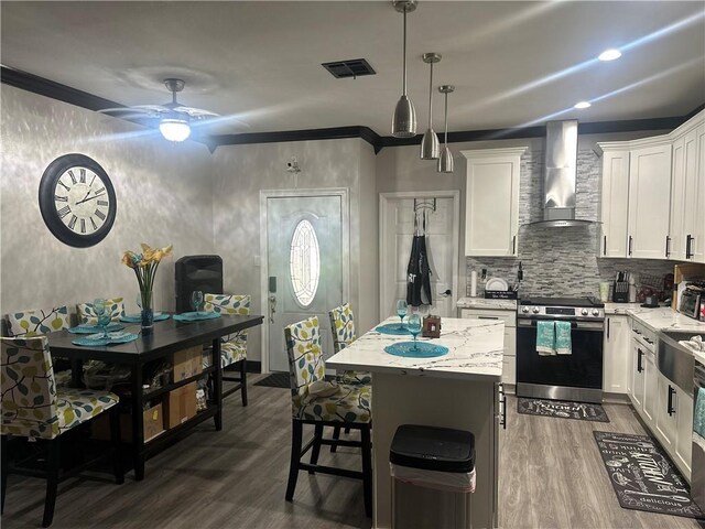 131 Belle Grove Dr, La Place, LA 70068 - kitchen with stainless steel range oven, wall chimney exhaust hood, dark wood-style flooring, light stone countertops, and white cabinets