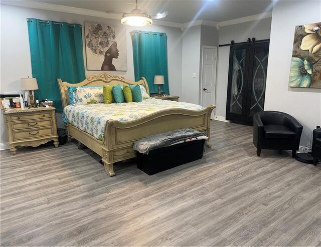 131 Belle Grove Dr, La Place, LA 70068 - bedroom with ornamental molding, wood finished floors, and a barn door