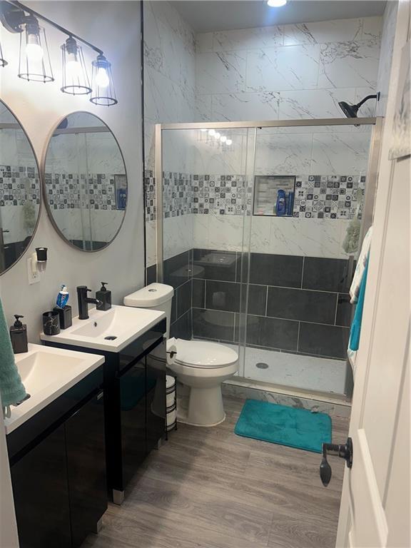 131 Belle Grove Dr, La Place, LA 70068 - bathroom with wood finished floors, vanity, and a shower stall