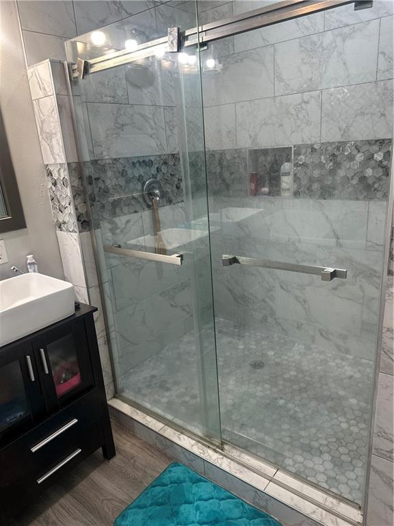 131 Belle Grove Dr, La Place, LA 70068 - full bathroom featuring wood finished floors, vanity, and a stall shower