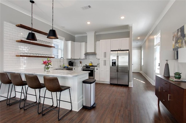 637 S Dupre St, New Orleans, LA 70119 - kitchen with appliances with stainless steel finishes, wall chimney range hood, a peninsula, tasteful backsplash, and a sink