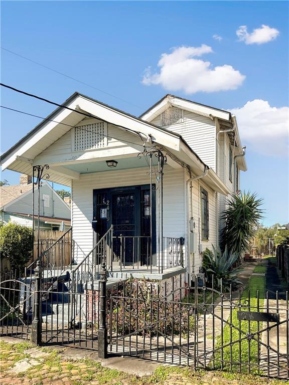 2419 Chippewa St, New Orleans, LA 70130 - shotgun-style home with covered porch and a fenced front yard