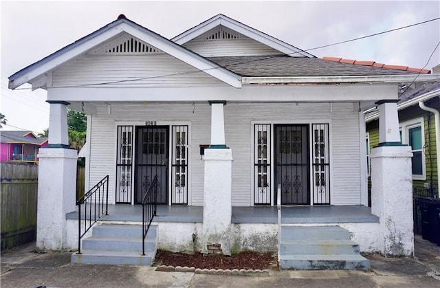 382426 Royal St, New Orleans, LA 70117 - shotgun-style home with a porch and a shingled roof