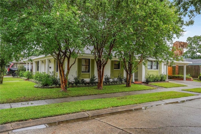 601 Andrews Ave, Metairie, LA 70005 - view of front of home with driveway, brick siding, a front lawn, and an attached carport
