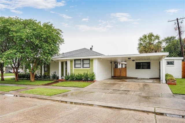 601 Andrews Ave, Metairie, LA 70005 - ranch-style home with concrete driveway, brick siding, a front lawn, and an attached carport