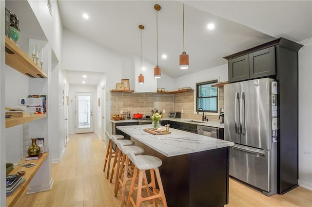 601 Andrews Ave, Metairie, LA 70005 - kitchen with open shelves, stainless steel appliances, lofted ceiling, decorative backsplash, and light wood-style floors