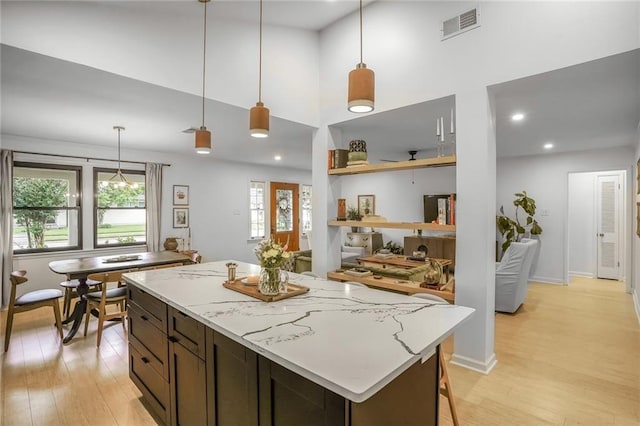 601 Andrews Ave, Metairie, LA 70005 - kitchen with light wood-style flooring, decorative light fixtures, a high ceiling, a center island, and recessed lighting