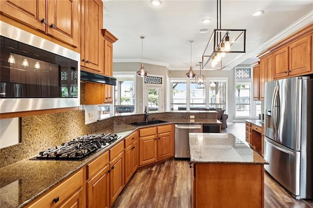 1037 Scarlet Oak Ln, Mandeville, LA 70448 - kitchen with appliances with stainless steel finishes, a sink, crown molding, a peninsula, and healthy amount of natural light