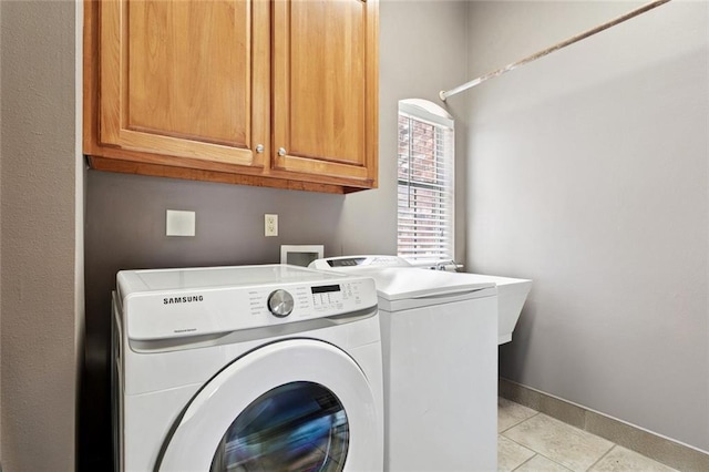 1037 Scarlet Oak Ln, Mandeville, LA 70448 - laundry room featuring separate washer and dryer, cabinet space, light tile patterned floors, and baseboards
