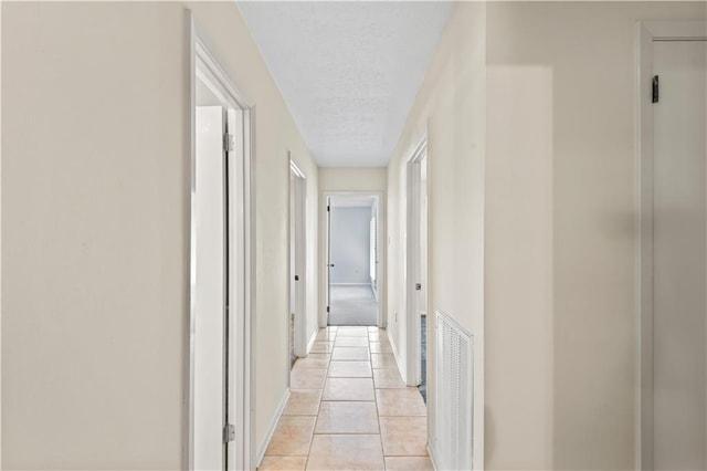 213 N Jayson Dr, Slidell, LA 70458 - hallway featuring a textured ceiling, light tile patterned floors, and baseboards