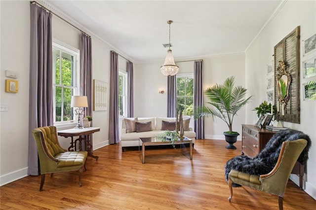 505 W 14th Ave, Covington, LA 70433 - living area with a chandelier, light wood finished floors, ornamental molding, and baseboards
