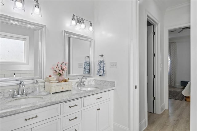 2828 Mistletoe St, New Orleans, LA 70118 - bathroom with double vanity, wood finished floors, baseboards, and crown molding